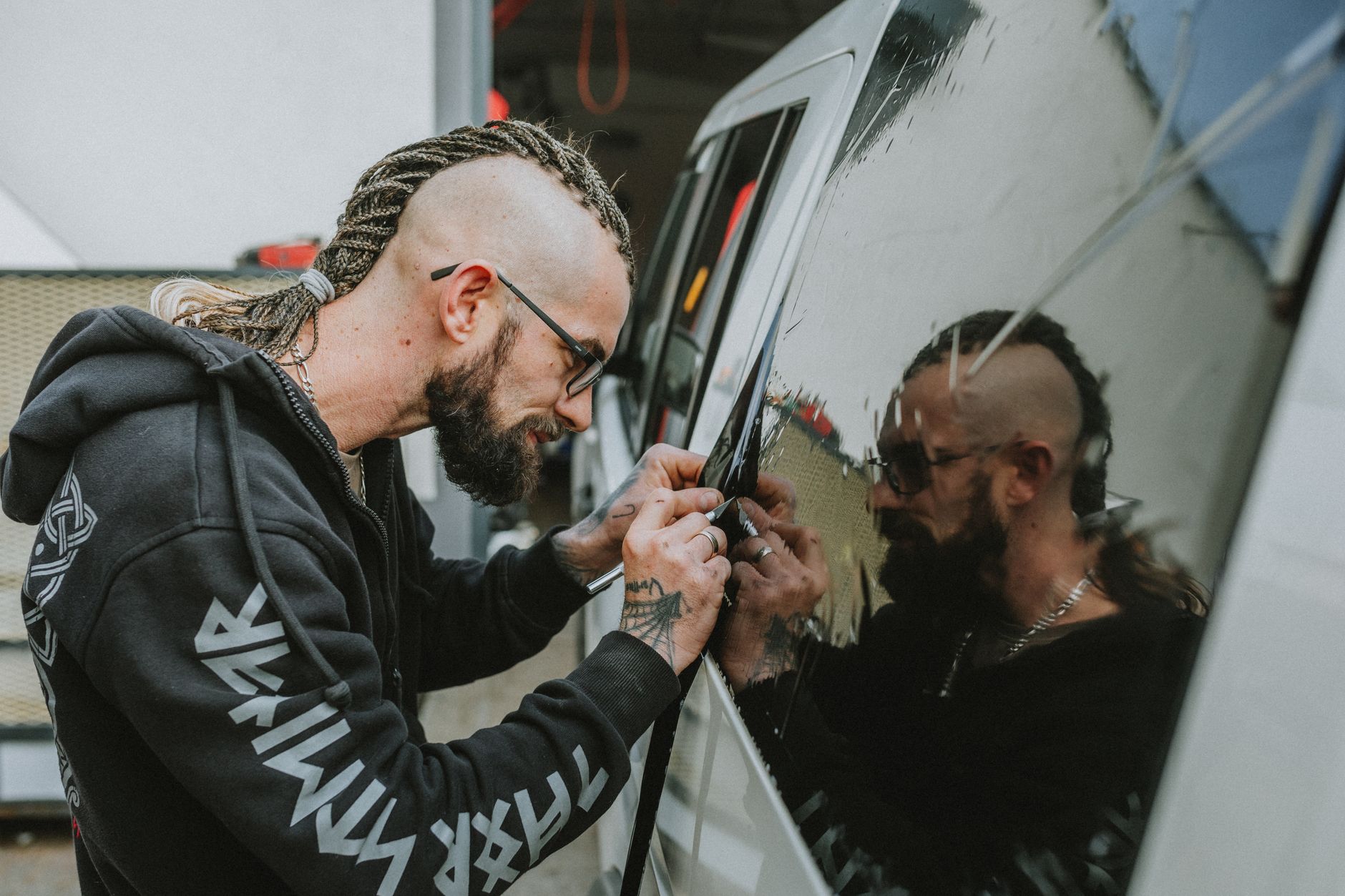 A technician applying window tint film to a car window
